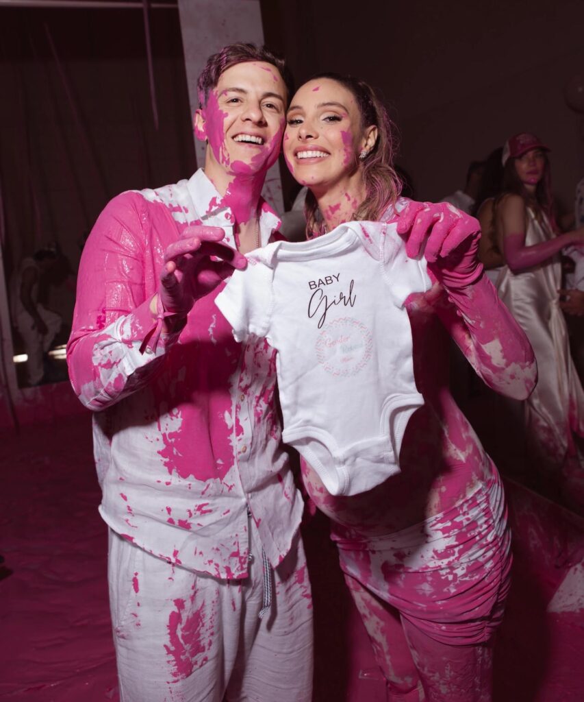 Fotografía cedida por EB Public Relations donde aparece la venezolana Lele Pons y el puertorriqueño Guaynaa manchados de color rosa y sosteniendo un vestido infantil de niñas durante la fiesta de revelación del sexo de su bebé celebrada este viernes en el Faena Forum en Miami, Florida (EE.UU.). EFE/EB Public Relations