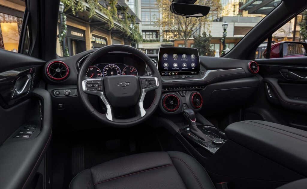 El interior del Blazer AWD RS 2023 es espacioso y cómodo, con asientos deportivos de cuero y gamuza con costuras rojas y una pantalla táctil de 8 pulgadas. 
