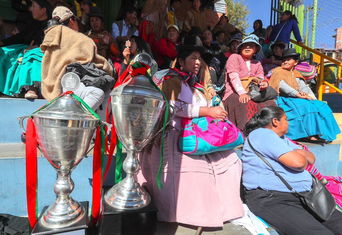 AME4657. LA PAZ (BOLIVIA), 08/07/2019.- Mujeres aimaras de los mercados de la ciudad participan en la inauguración del campeonato "Caserita metegol" este lunes, en La Paz (Bolivia). Estas mujeres, que en su mayoría son "cholitas", las emblemáticas aimaras bolivianas, cambiaron su vestimenta tradicional con blusa y polleras por uniformes y zapatillas de fútbol para asistir a la inauguración de la novena edición del campeonato "Caserita metegol". Con globos, pancartas, trompetas e incluso un bombo, centenares de entusiastas vendedoras y sus familias colmaron las gradas de la cancha municipal San Luis, en el oeste de la ciudad, para hacer barra durante la presentación de los equipos. EFE/ Martin Alipaz