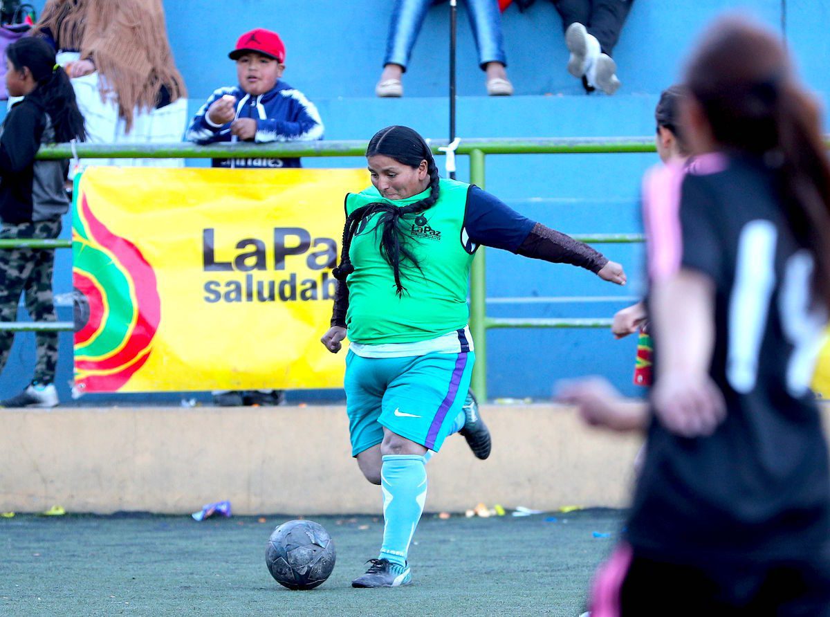 AME4657. LA PAZ (BOLIVIA), 08/07/2019.- Una integrante del equipo del mercado Uruguay en acción durante el partido inaugural del campeonato "Caserita metegol" este lunes, en La Paz (Bolivia). Estas mujeres, que en su mayoría son "cholitas", las emblemáticas aimaras bolivianas, cambiaron su vestimenta tradicional con blusa y polleras por uniformes y zapatillas de fútbol para asistir a la inauguración de la novena edición del campeonato "Caserita metegol". Con globos, pancartas, trompetas e incluso un bombo, centenares de entusiastas vendedoras y sus familias colmaron las gradas de la cancha municipal San Luis, en el oeste de la ciudad, para hacer barra durante la presentación de los equipos. EFE/ Martin Alipaz