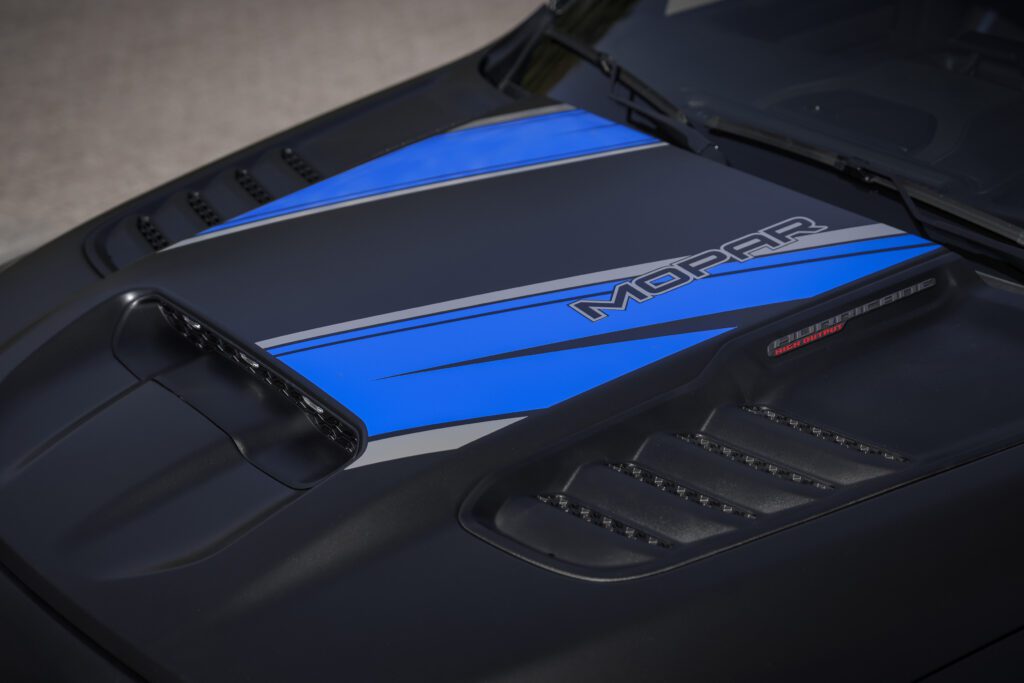 Los llamativos gráficos personalizados en azul Mopar del capó del Ram 1500 RHO Moparizado contrastan con el exterior en negro diamante metalizado satinado.