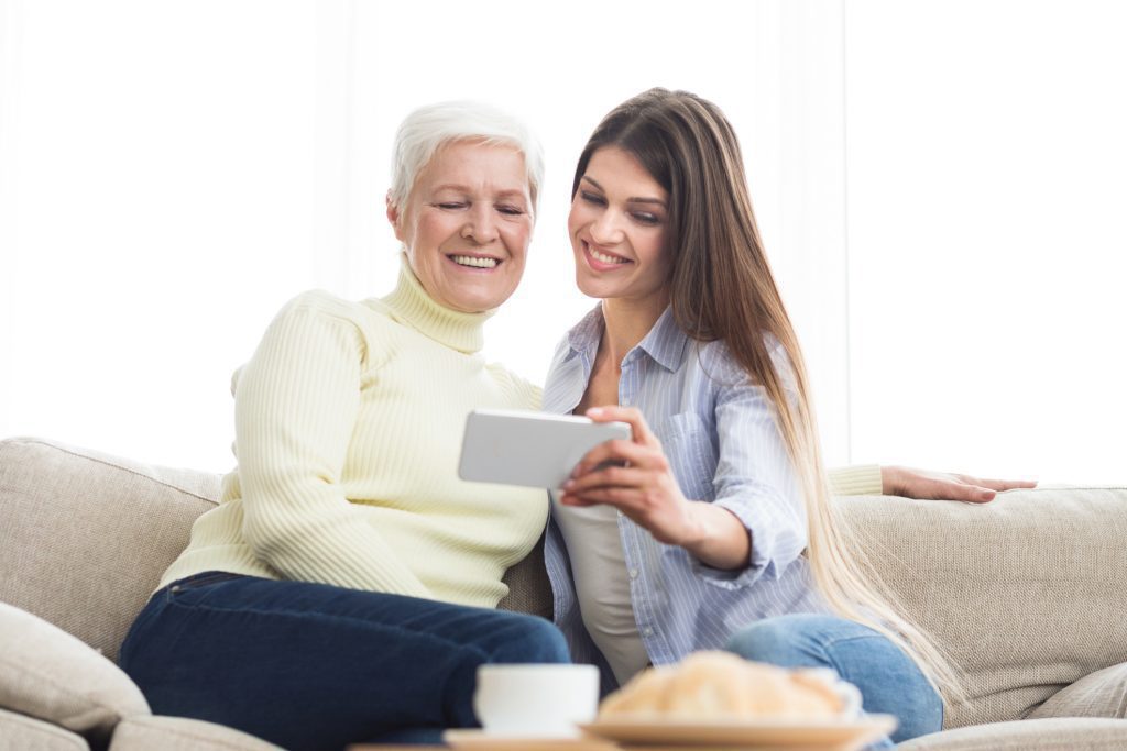 Mature mother and young daughter taking selfie