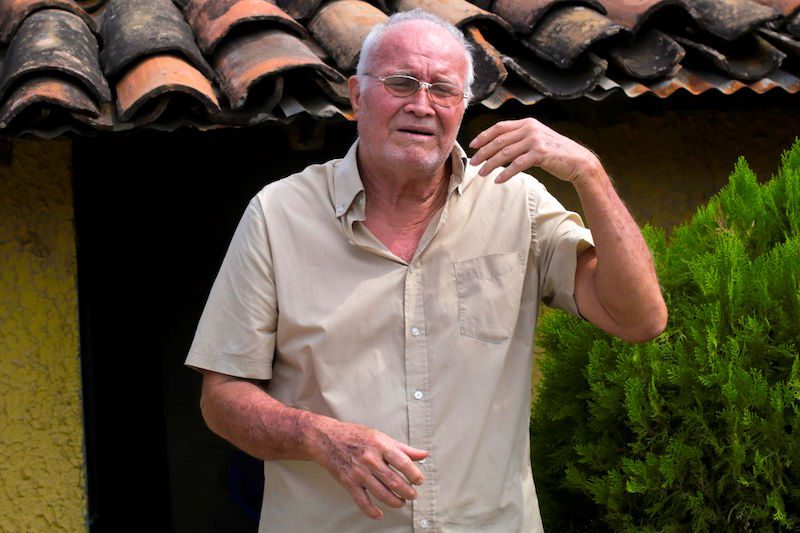 Fotografía fechada el 18 de mayo de 2019 que muestra al exalcalde de Goascoran Harvy López Reyes mientras habla en entrevista con Efe sobre el conflicto bélico entre Honduras y El Salvador, en Goascoran (Honduras). De la guerra que los Ejércitos de Honduras y El Salvador libraron hace 50 años por un centenario contencioso limítrofe y migratorio sobreviven unos 2.000 excombatientes hondureños, lo mismo que muchos civiles, como un exalcalde que fue alcanzado por cuatro disparos el día que se inició la invasión del vecino país, el 14 de julio de 1969. EFE/ Gustavo Amador