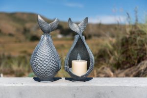 Diving Fish Candleholder - Fundido a mano en aluminio con un acabado azul verdín con reflejos de bronce. Mide 12.5 "de alto y admite una vela de 3" de diámetro.