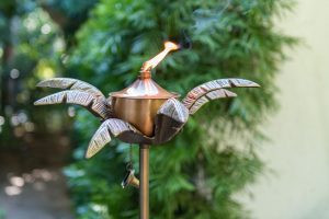 Palm Fronds Torch - Aluminio fundido a mano y hierro con un acabado de cobre. Lleva aceite para lámpara (no incluido) y una vez plantado mide aproximadamente 48 "de altura.